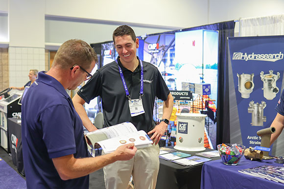 Représentant d'Hydrasearch en conversation avec un participant à l'événement